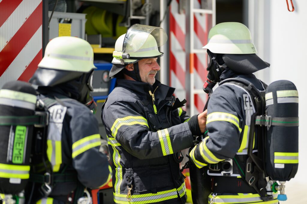 Feuerwehrleute bei Einsatzvorbereitung am Feuerwehrfahrzeug.