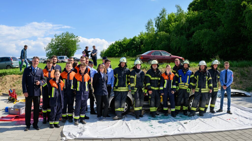 Gruppe von Feuerwehrleuten und Freiwilligen im Freien.