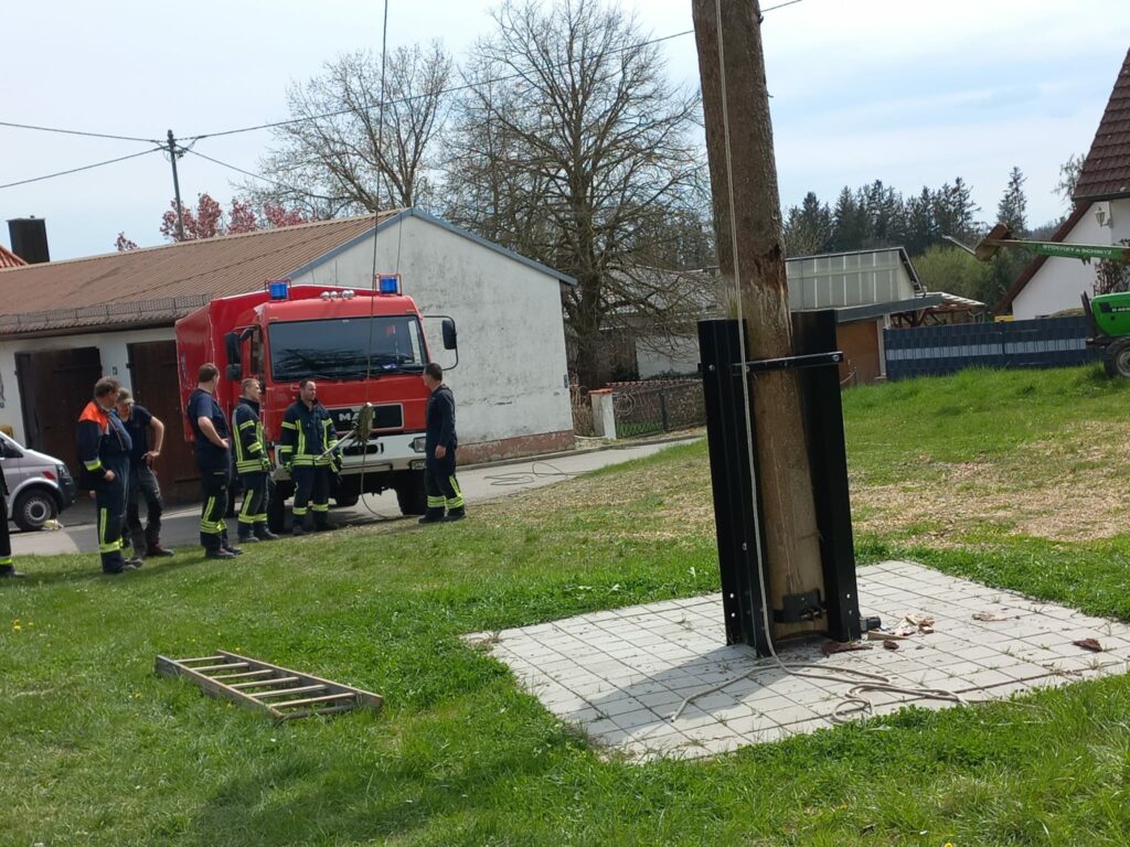 Feuerwehrleute bei Einsatz mit rotem Feuerwehrfahrzeug.