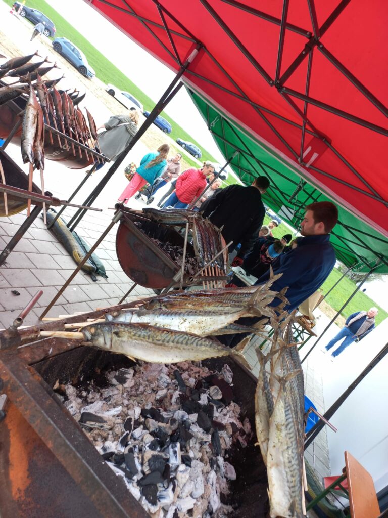 Gegrillte Fische unter roten Markisen bei Marktfest.