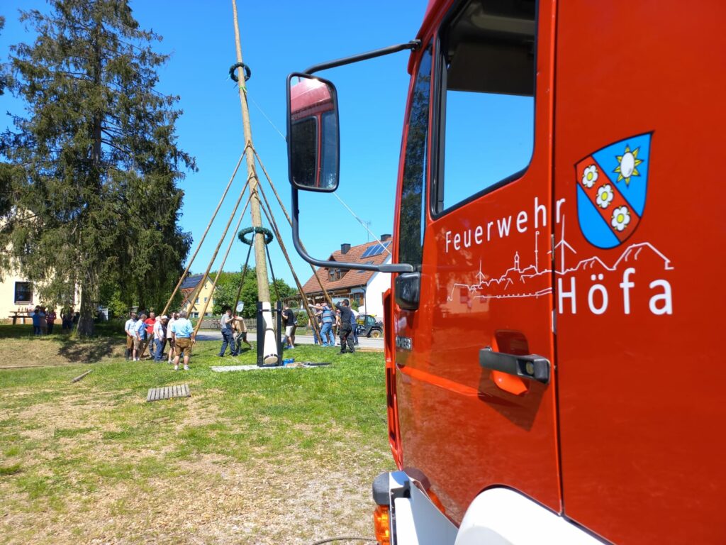 Feuerwehr im Einsatz beim Aufstellen eines Maibaums.