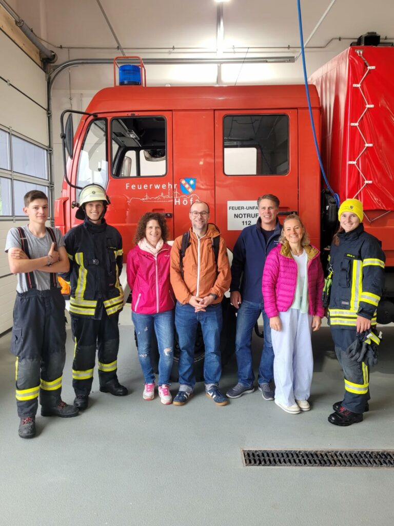 Gruppe posiert vor Feuerwehrauto
