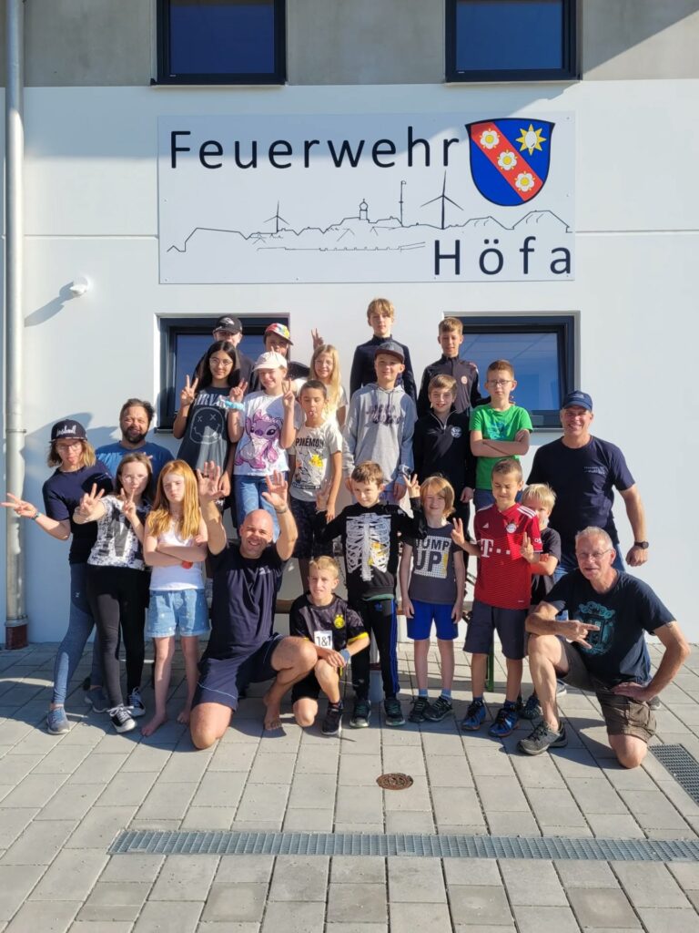 Gruppe posiert vor Feuerwehrgebäude