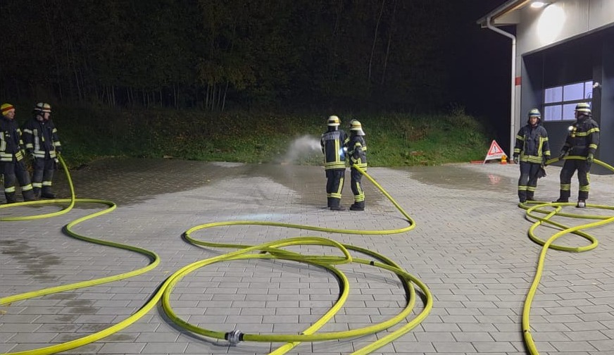Feuerwehrübung mit Schläuchen im Freien