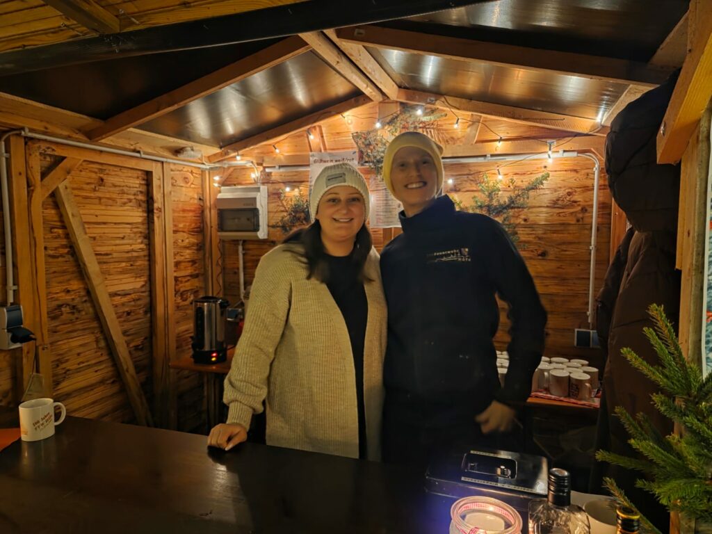 Zwei Personen in einer festlichen Holzhütte