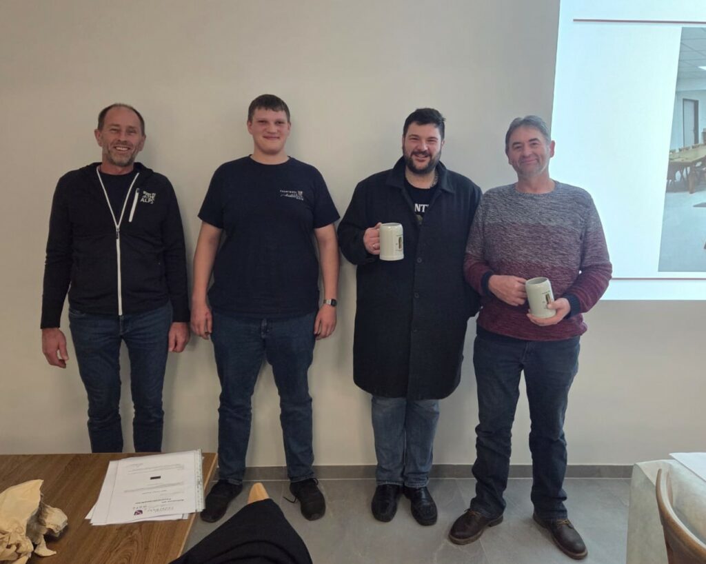 Vier Männer stehen lächelnd zusammen.